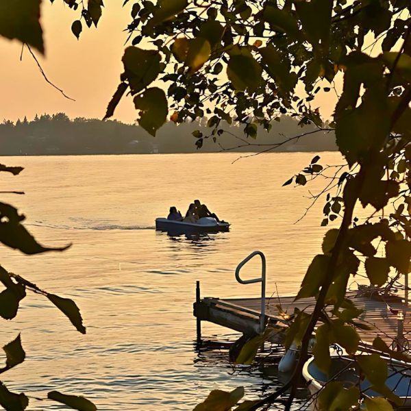 Three people in a peddle boat during sunset, showcasing family fun at Inverness Falls Resort.