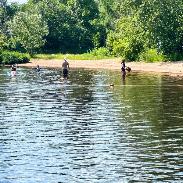 The beach at Inverness Falls Resort where adults and kids are enjoying family fun.