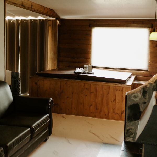 Hot tub in the main living area inside an Inverness Falls Resort cabin, highlighting the relaxing experience of their honeymoon packages.