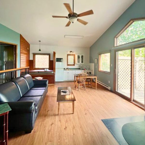 Inside look of a cottage's living area, dining area, and kitchen, showcasing the open layout of Inverness' accommodations.