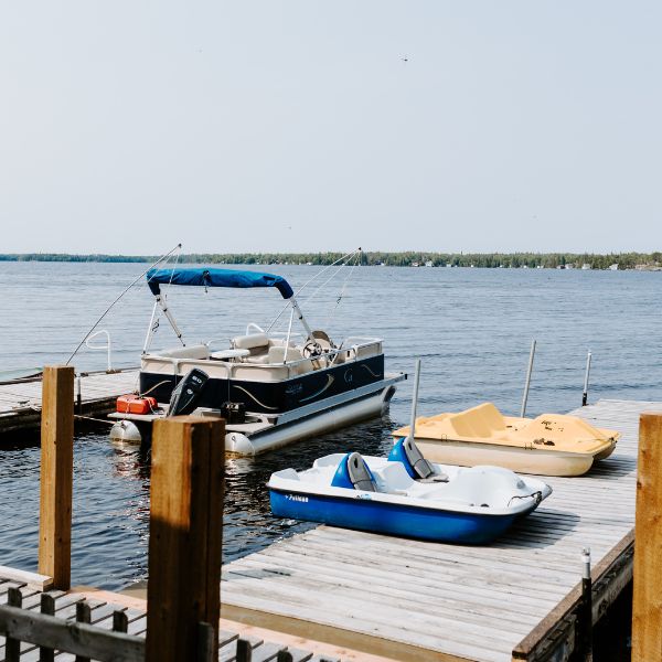 Inverness dock with a boat and peddle boats stationed by, showcasing the adventure opportunities couples can experience with Inverness Falls Resort's honeymoon packages.